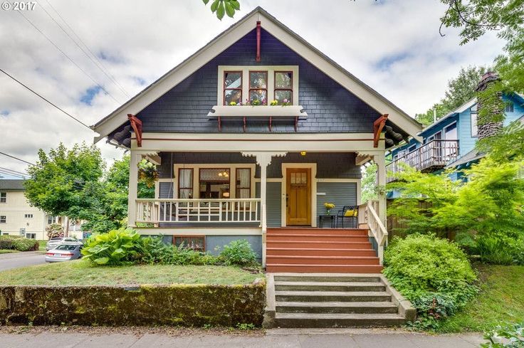 a blue house with stairs leading up to the front door