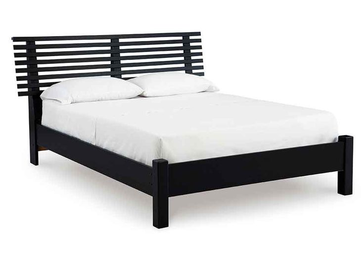 a black bed frame with white pillows and sheets on top of it, against a white background