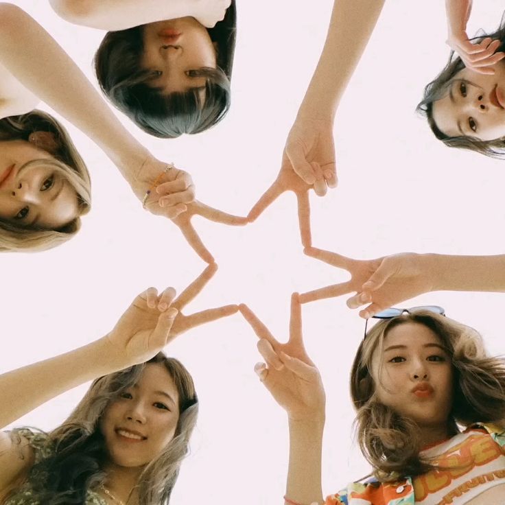 four girls holding their hands together in the shape of a star