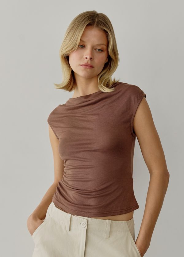 The ali top is a must to add to your everyday wear collection. it's crafted from a soft washed modal fabrication in a fitted silhouette. features a flattering cowl neckline and side ruching detail for added style. wear yours with a pleated skirt or wide-leg pants with high boots.    73% modal 27% polyester Chic Brown Ruched Tops, Everyday Modal Fitted Tops, Fitted Modal Tops For Everyday, Versatile Fitted Cowl Neck Top, Fitted Modal Casual Tops, Fitted Casual Modal Tops, Stretch Solid Color Cowl Neck Top, Fitted Brown Ruched Top, Casual Stretch Cowl Neck Tops