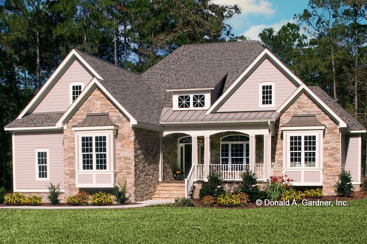 a house in the middle of a field with lots of grass and trees around it