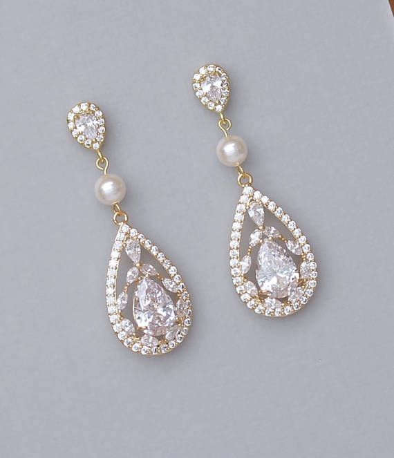 two pairs of gold and white earrings with pearls on the bottom, one has a tear shaped