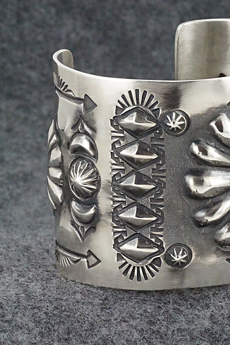 This stunning sterling silver bracelet was made by Navajo silversmith Elvira Bill. The inside is signed Elvira Bill and stamped sterling.Size: 5 7/8" (will fit up to a 7 1/4" wrist)Gap: 1 3/8"Width: 2"Free shipping on all orders! We ship with USPS and always include tracking. All orders ship within a day of payment.Returns are accepted up to 30 days after you receive your order. Just send us a message. Our shop offers cash back or store credit. The item must be returned in new condition. Artisan Sterling Silver Bracelet With Etched Details, Artisan Silver Bracelet With Stamped Details, Sterling Silver Southwestern Bracelet With Polished Finish, Artisan Sterling Silver Concho Cuff Bracelet, Silver Cuff Bracelet With Stamped Details, Unique Silver Stamped Cuff Bracelet, Artisan Silver Concho Cuff Bracelet, Artisan Silver Etched Cuff Bracelet, Southwestern Silver Bracelets With Concho