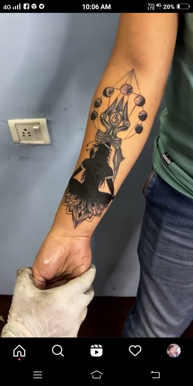 a person with a black and white tattoo on their arm holding something in his hand