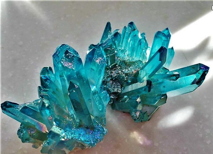 two blue crystals sitting on top of a white table