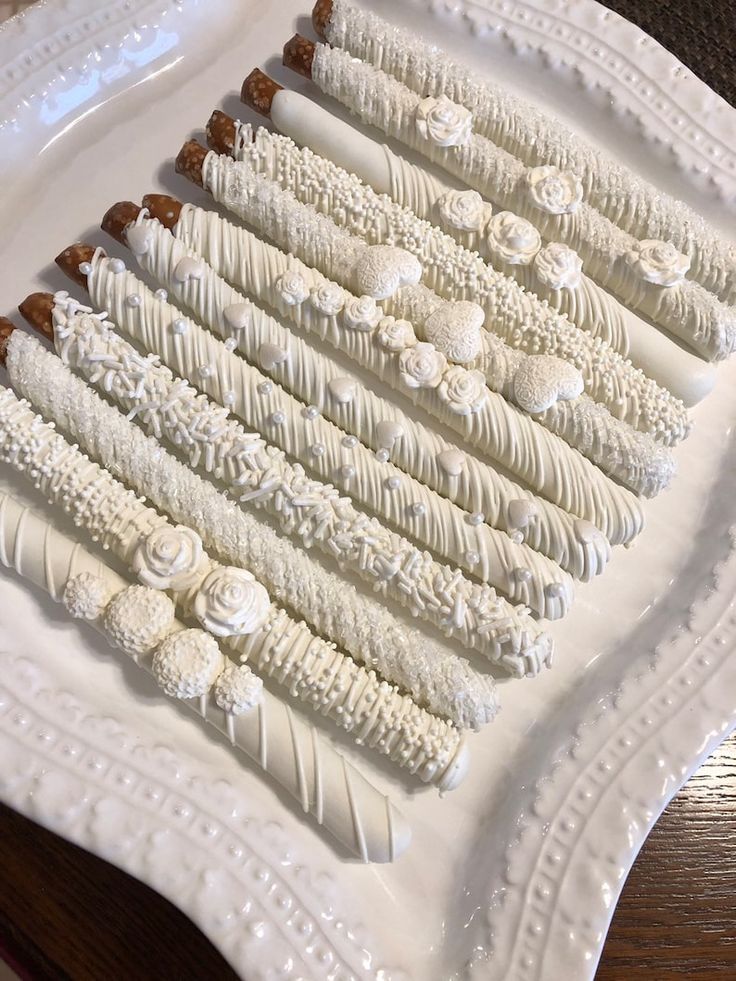 a white platter filled with lots of different types of desserts on top of a wooden table