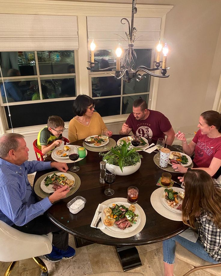 a group of people sitting around a table eating food