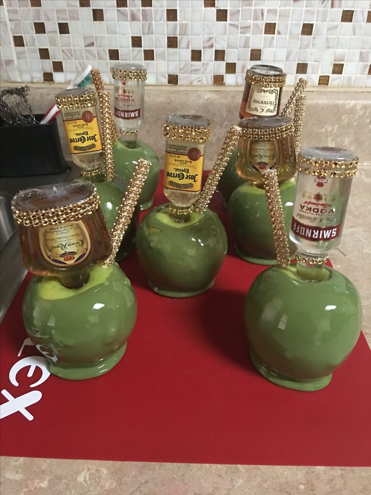 seven jars of jam sitting on top of a red mat in front of a counter