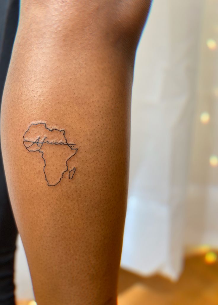 a person with a tattoo on their leg showing the outline of africa and its country