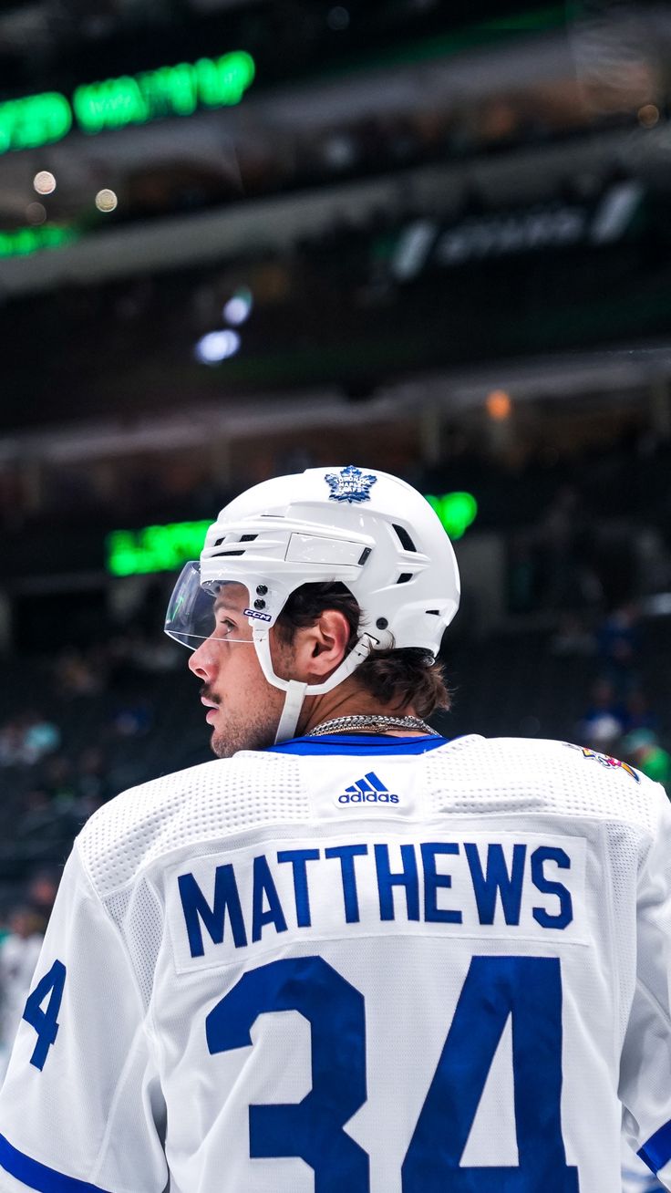 a hockey player wearing a white and blue jersey with the number 34 on it's chest