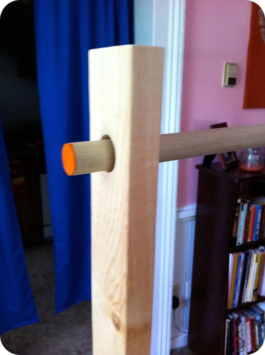 a wooden door handle with an orange knob on it