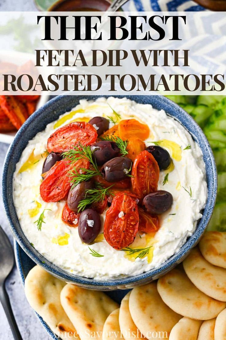 the best feta dip with roasted tomatoes in a blue bowl surrounded by crackers