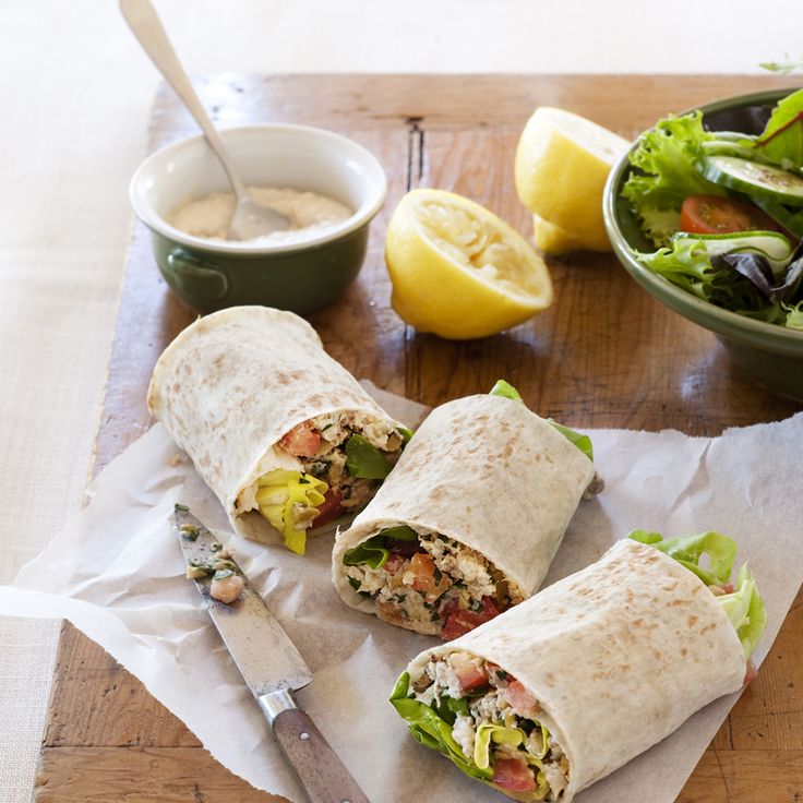 there is a wrap that has been cut in half and sitting on a cutting board