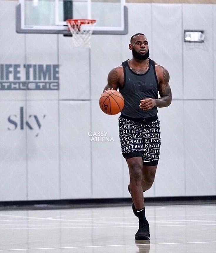 a man with a basketball in his hand on the court at an indoor gym playing basketball