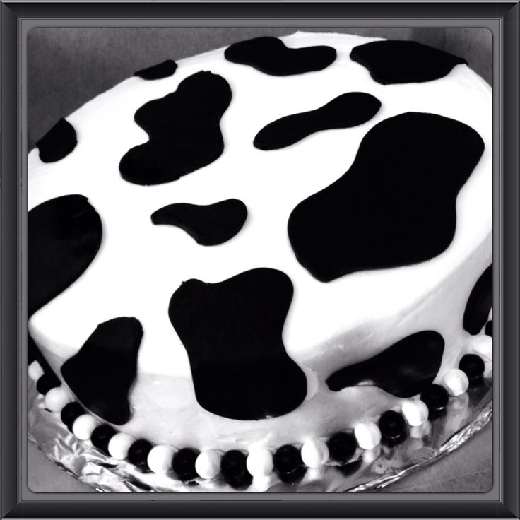 a black and white cow print cake with icing on the top is ready to be eaten