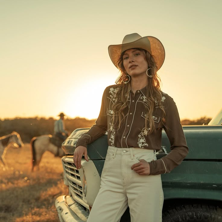 This snap-front western shirt offers classic style with heritage details like contrast piping and embroidery. It’s constructed with extremely soft rayon crepe and features a single-point front and back yoke, an oversized collar with piping, and smile pockets. This shirt is equally at home out on the ranch or out on the town. 100% Rayon Boyfriend Fit Single Point Curved Front and Back Yokes Front Faux Pocket Flaps Imported Western Theme Womens Outfit, Modern Western Clothing, Pearl Snap Shirts Women Outfit Western, Western Suits Women, Women’s Western Wear, Cowboy Werewolf, Western Shirt Outfit, Formal Cowgirl Outfits, 80s Western Fashion