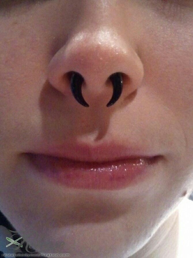 a close up of a person's nose with an upside down nose ring on it