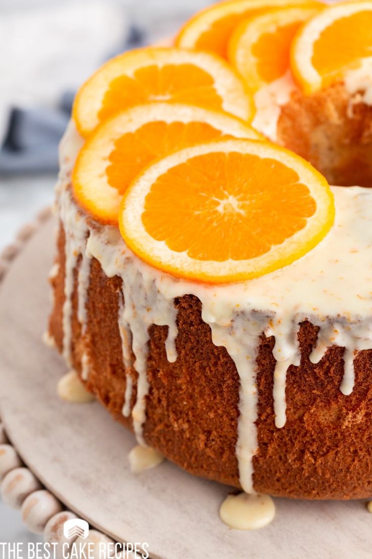 an orange cake with icing and sliced oranges on top