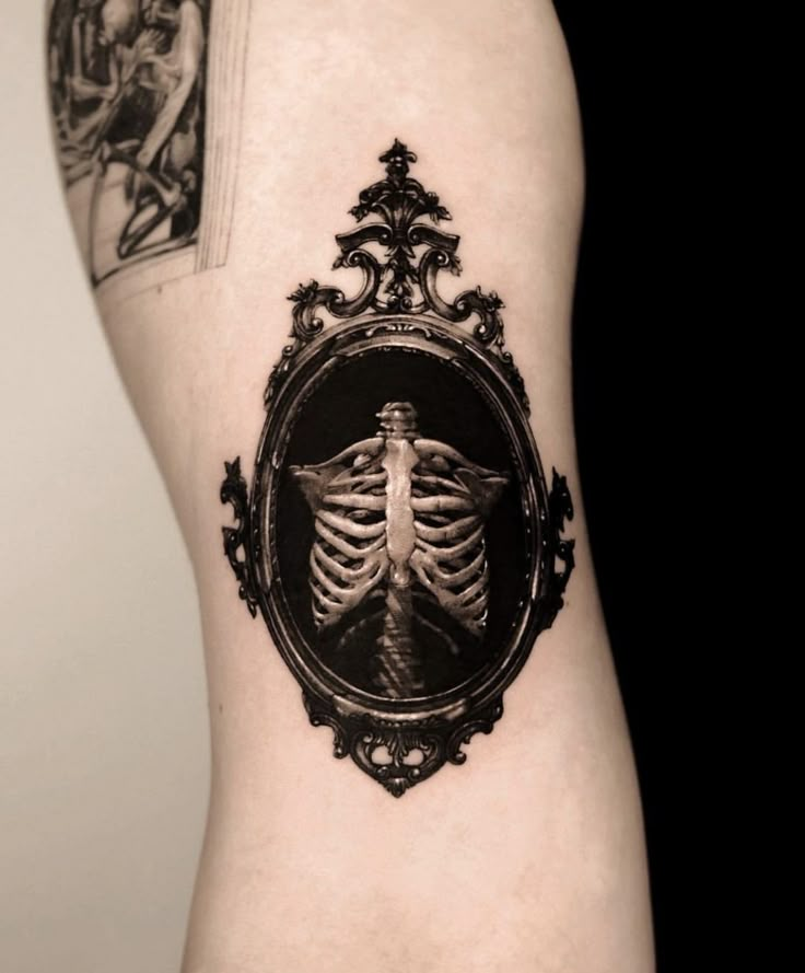 a skeleton in a frame tattoo on the back of a woman's leg,