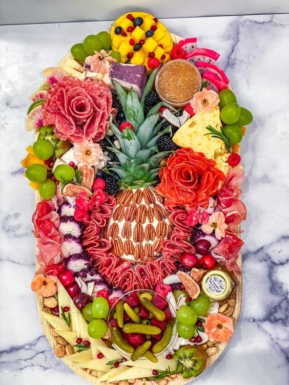 an arrangement of fruits and vegetables arranged in the shape of a face on a marble surface