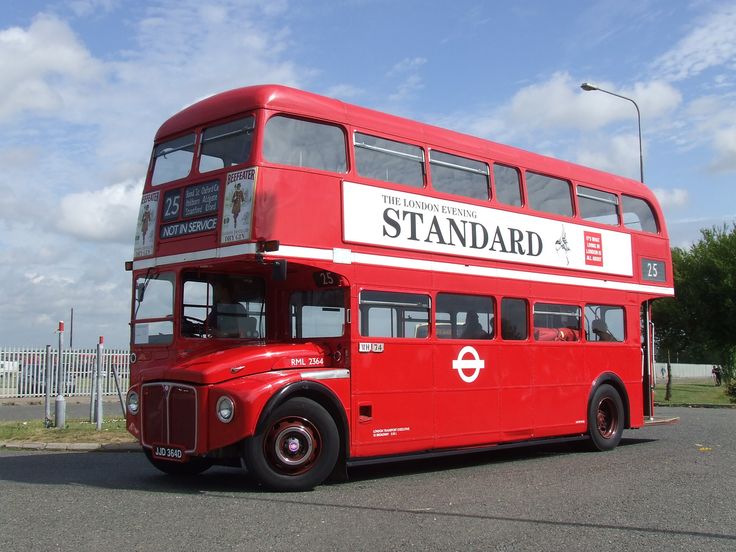 a red double decker bus driving down the street