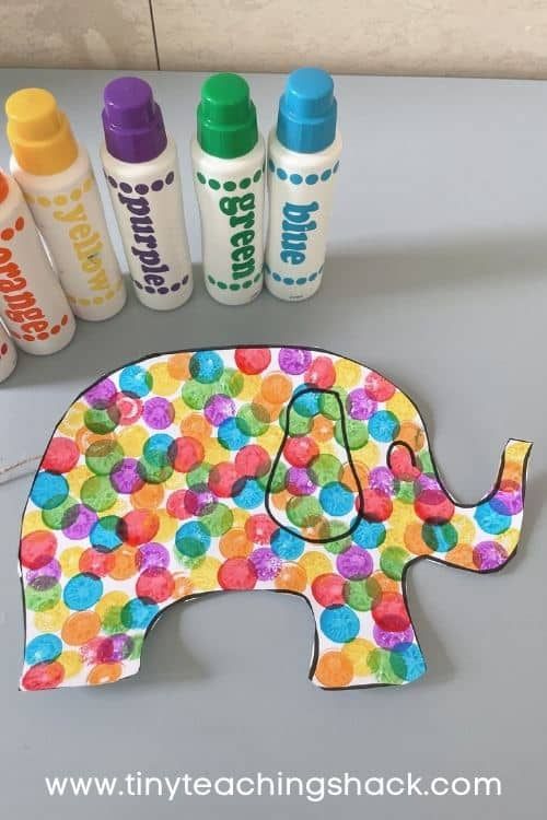 an elephant made out of crayons next to markers