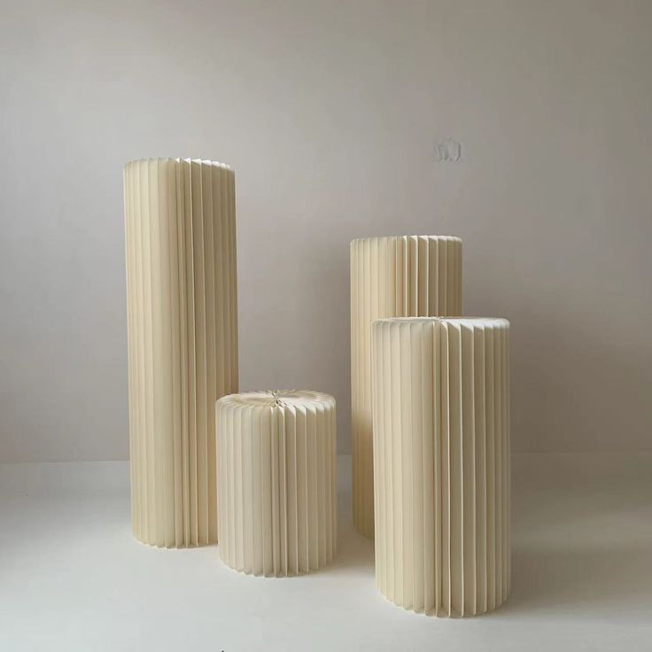 three white vases sitting next to each other on a table