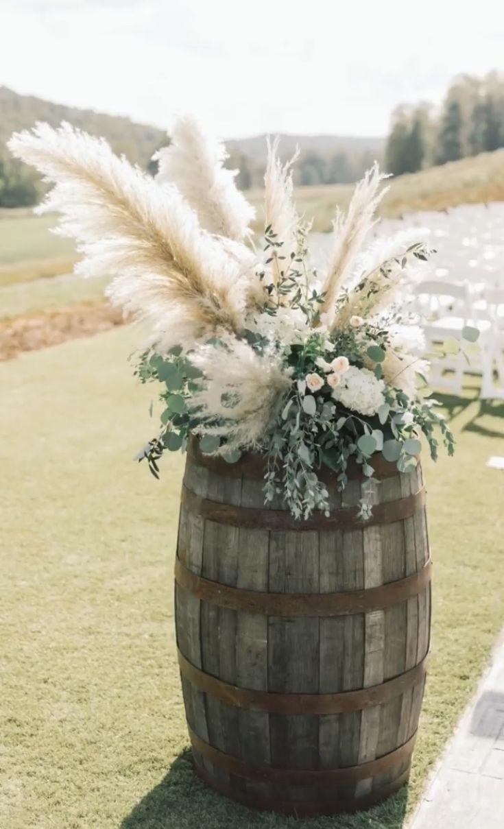 a wooden barrel filled with flowers and feathers