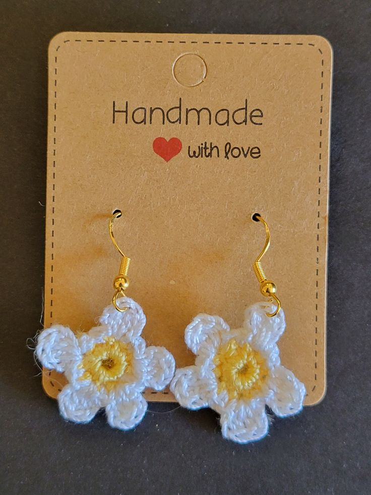 two crocheted flowers are attached to earwires on a card with the words handmade with love