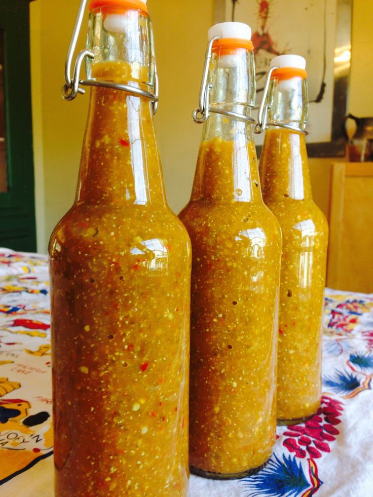 three bottles filled with mustard sitting on top of a table