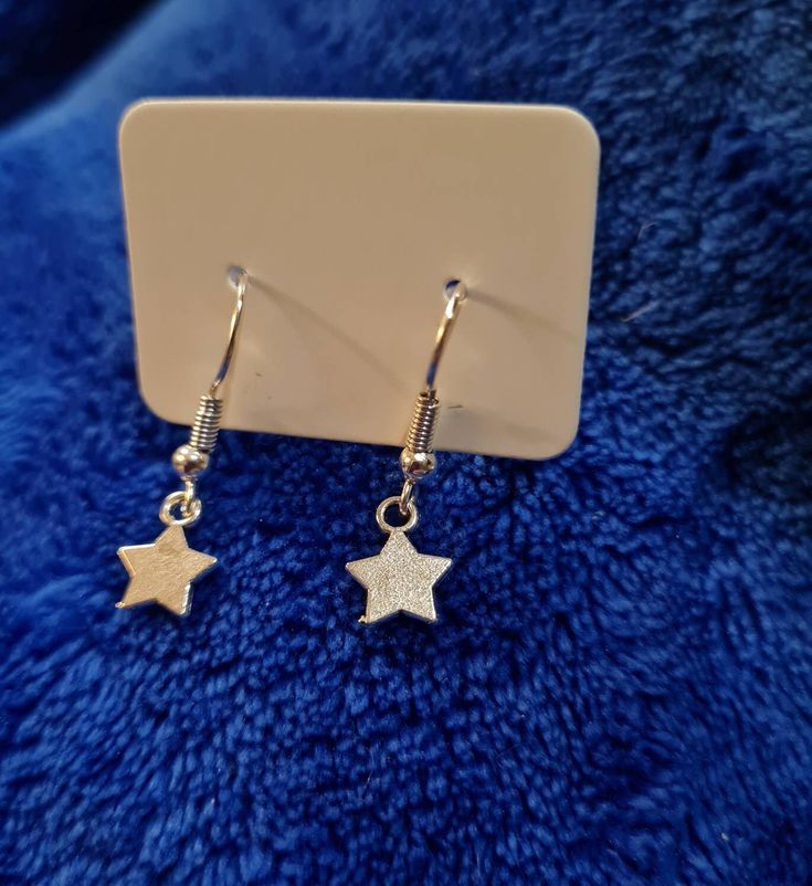 Lovely drop star earrings. Made with hypoallergenic stainless steel. Perfect as a gift. I aim to post same day. Thank you for looking :) Metal Drop Earrings With Star Charm, Nickel-free Metal Star Earrings, Nickel-free Star-shaped Metal Earrings, Nickel-free Star Shaped Metal Earrings, Star-shaped Earrings With Ear Wire For Everyday, Everyday Star Shaped Pierced Earrings, Everyday Drop Earrings With Star Charm, Trendy Silver Star Earrings, Minimalist Star Charm Earrings As Gift