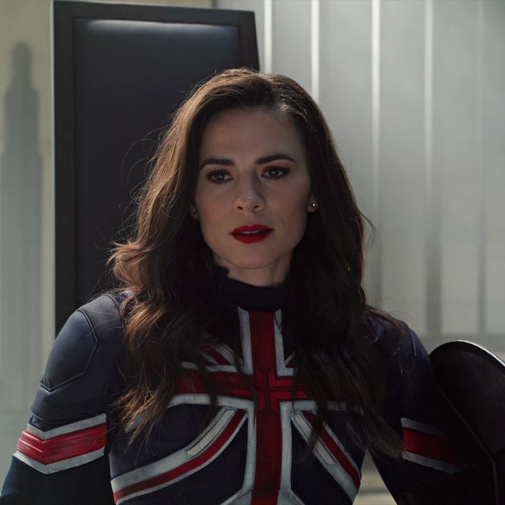 a woman wearing a union jack shirt and red lipstick