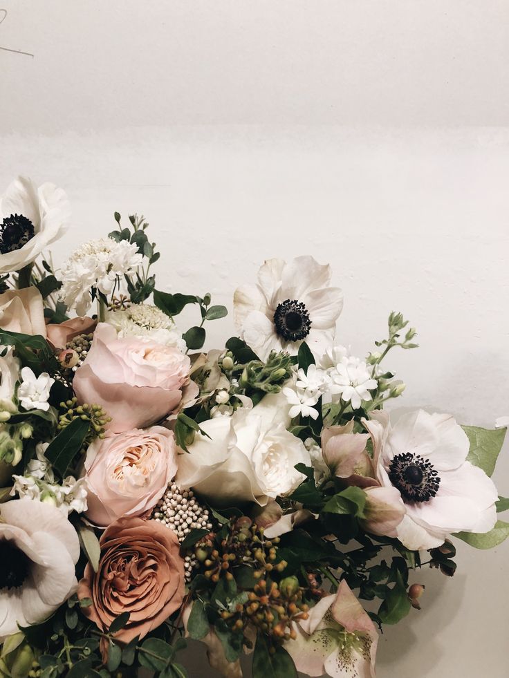 a vase filled with lots of white and pink flowers