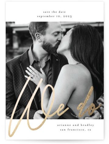 an elegant save the date card with gold foil on it and a photo of a couple kissing