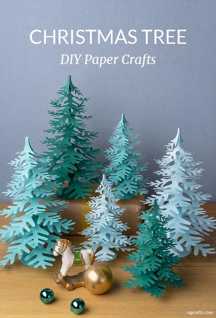 christmas tree diy paper crafts with gold and green ornaments on a wooden table next to trees