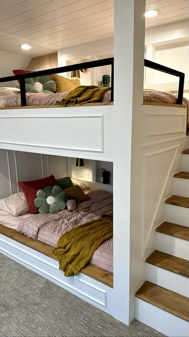 the bunk bed is built into the side of the wall and has stairs leading up to it