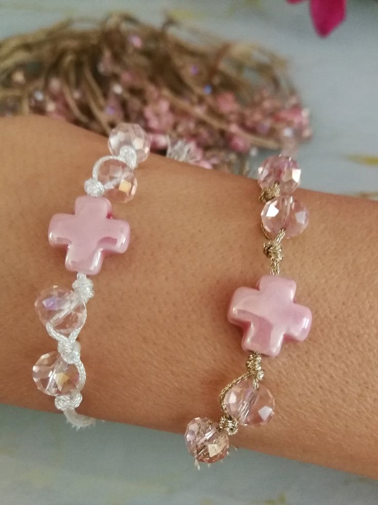 a close up of a person's arm wearing a bracelet with cross charms on it