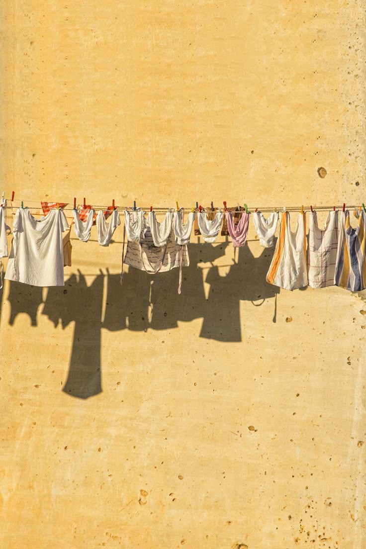 clothes hanging out to dry in the sun on a line with no one around them