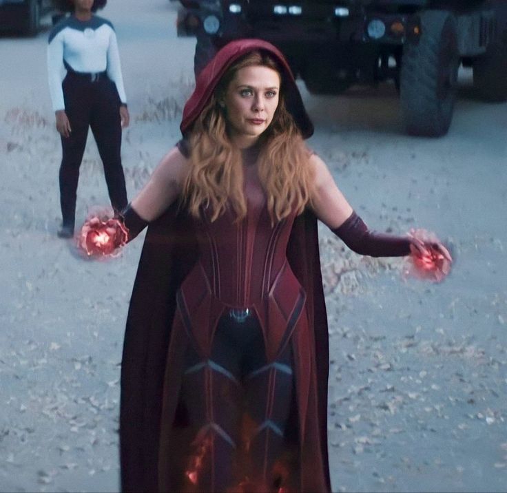 a woman dressed as the avengers stands in front of two men