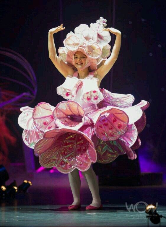 a woman in a pink dress is dancing on stage