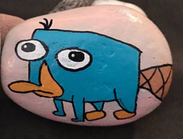 a painted rock with an image of a blue bird on it's face and legs