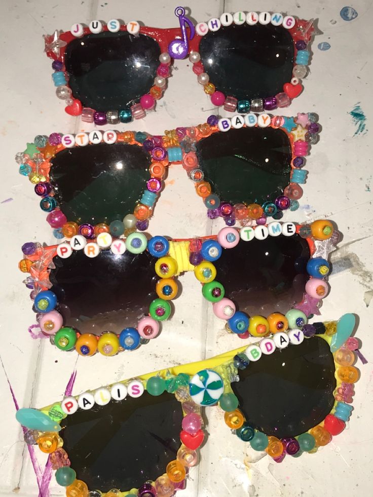 three pairs of sunglasses made out of buttons and plastic beads on top of a table