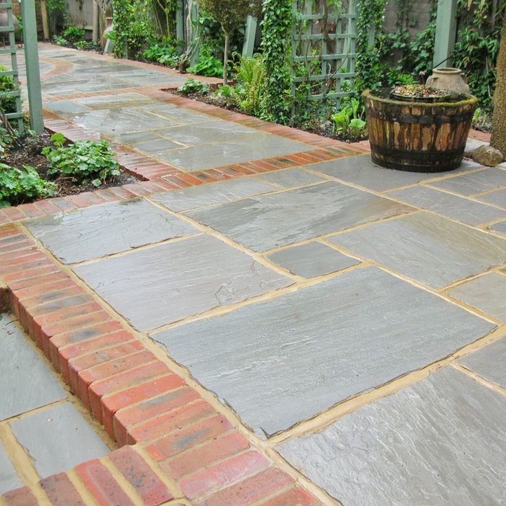 an outdoor patio with brick pavers and plants