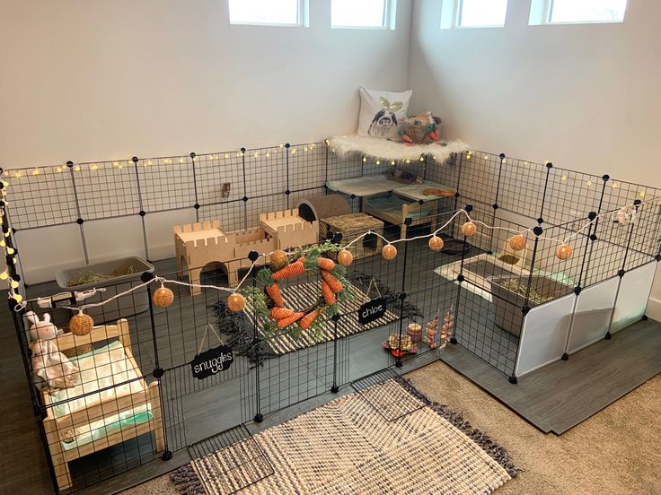 a caged in room with toys and other items on the floor next to it