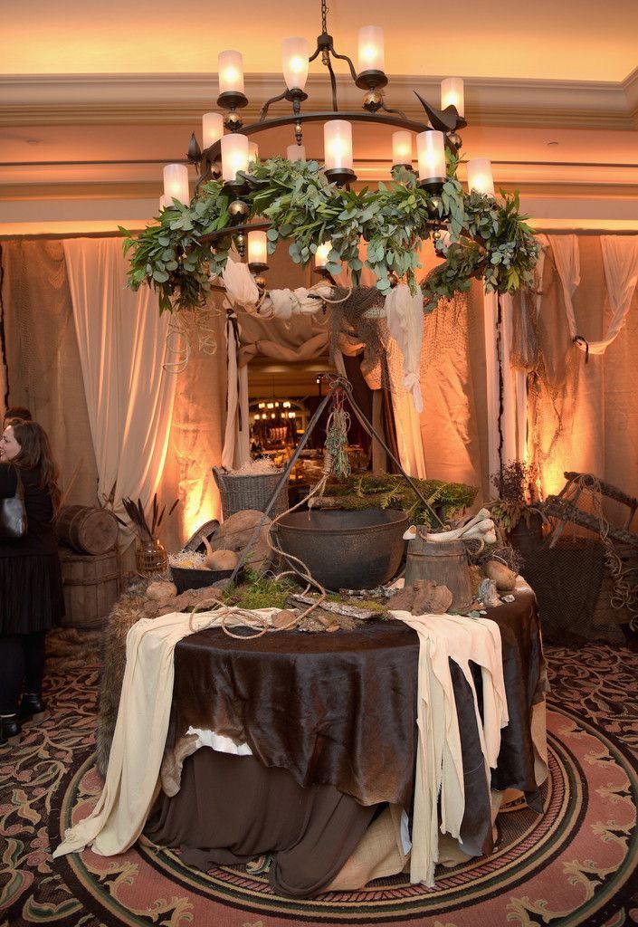 a table is set up in the middle of a room with candles and greenery