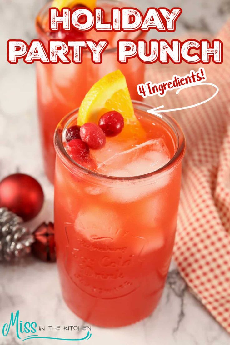 two glasses filled with holiday party punch and garnished with pomegranates