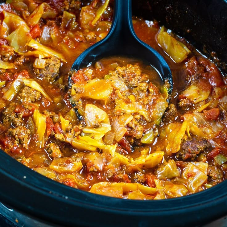 a slow cooker filled with meat and vegetable stew, ready to be cooked in the crock pot