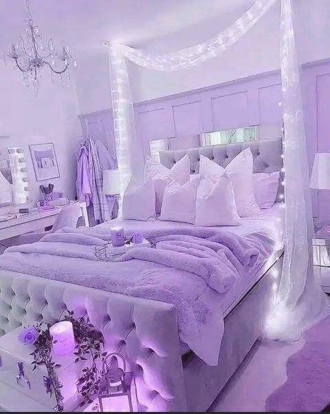 a white bed with purple comforter and pillows in a room decorated for christmas or new year's eve