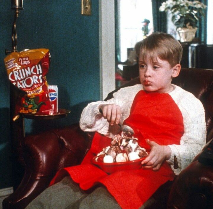 a young boy sitting in a chair eating food