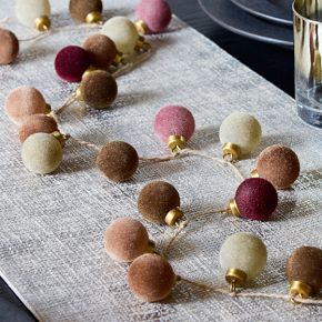 a table topped with lots of different colored balls on top of a cloth covered table